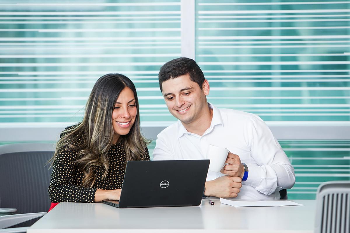 hombre y mujer sentados juntos y mirando un notebook